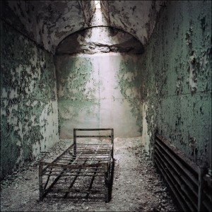 Promtional image: remains of a bed in a ruined room